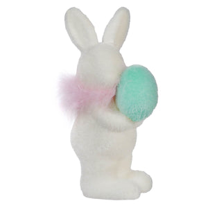 White ceramic bunny holding a turquoise Easter egg.