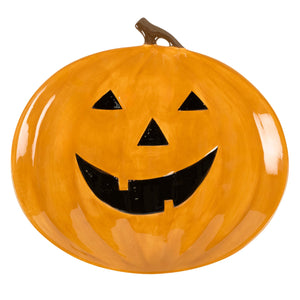 Vibrant orange ceramic jack o lantern platter with pumpkin design and black smiling face cutouts for festive use
