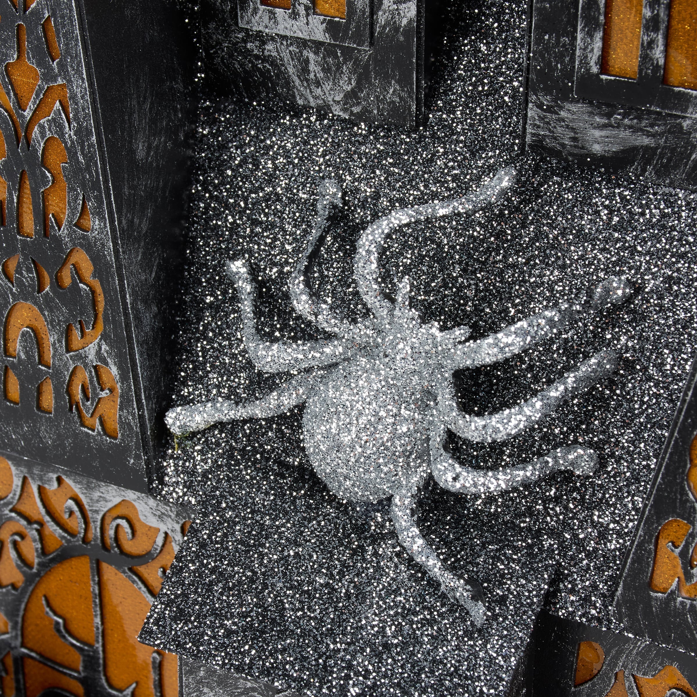 A glittery silver spider decoration with a sparkly textured surface for the lighted haunted house sitter dead & breakfast