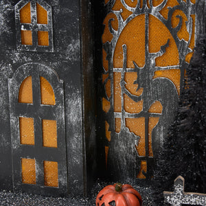 Black halloween-themed lighted haunted house sitter with orange glittery windows and a rustic finish for dead & breakfast decor