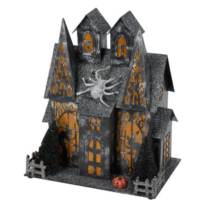 Black glittery lighted haunted house sitter with orange glowing windows and silver spider perfect for dead and breakfast decor