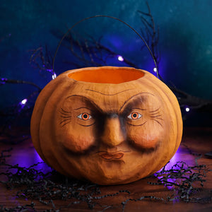 A carved orange jack-o-lantern candy bucket with detailed painted face perfect for halloween buckets and lanterns