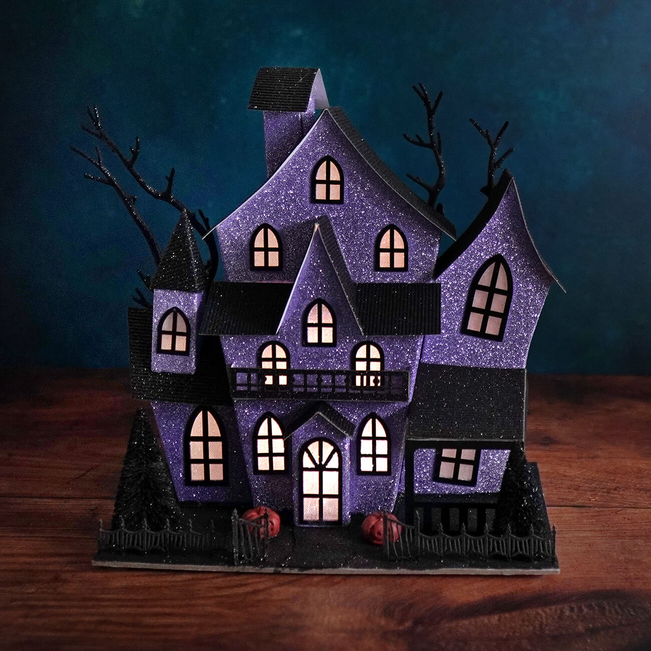 12 inch lighted purple haunted house with glitter, black accents, and glowing windows for halloween lights and decor