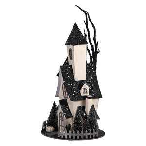 Black and white glittery halloween village house with tall steeple and tiny trees for spooky haunted house decor
