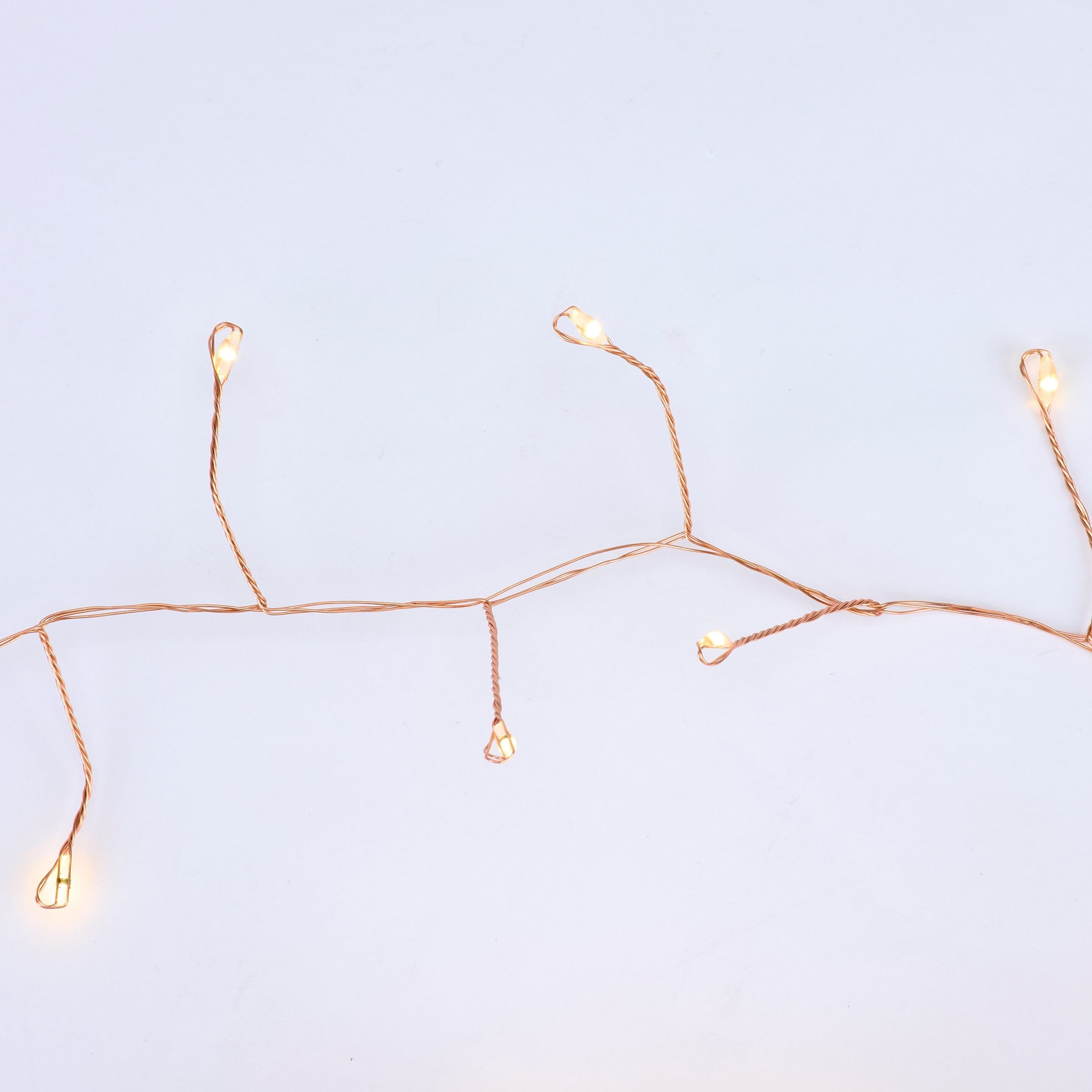 Copper string lights with delicate copper-colored candy cane wire and warm-toned led holiday lights in branching pattern