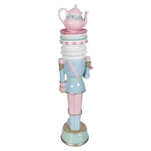 Pastel blue and pink resin dessert toy soldier balancing a decorative tea set on its head standing 15.75 inches tall
