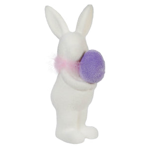White ceramic bunny holding a purple pom-pom.