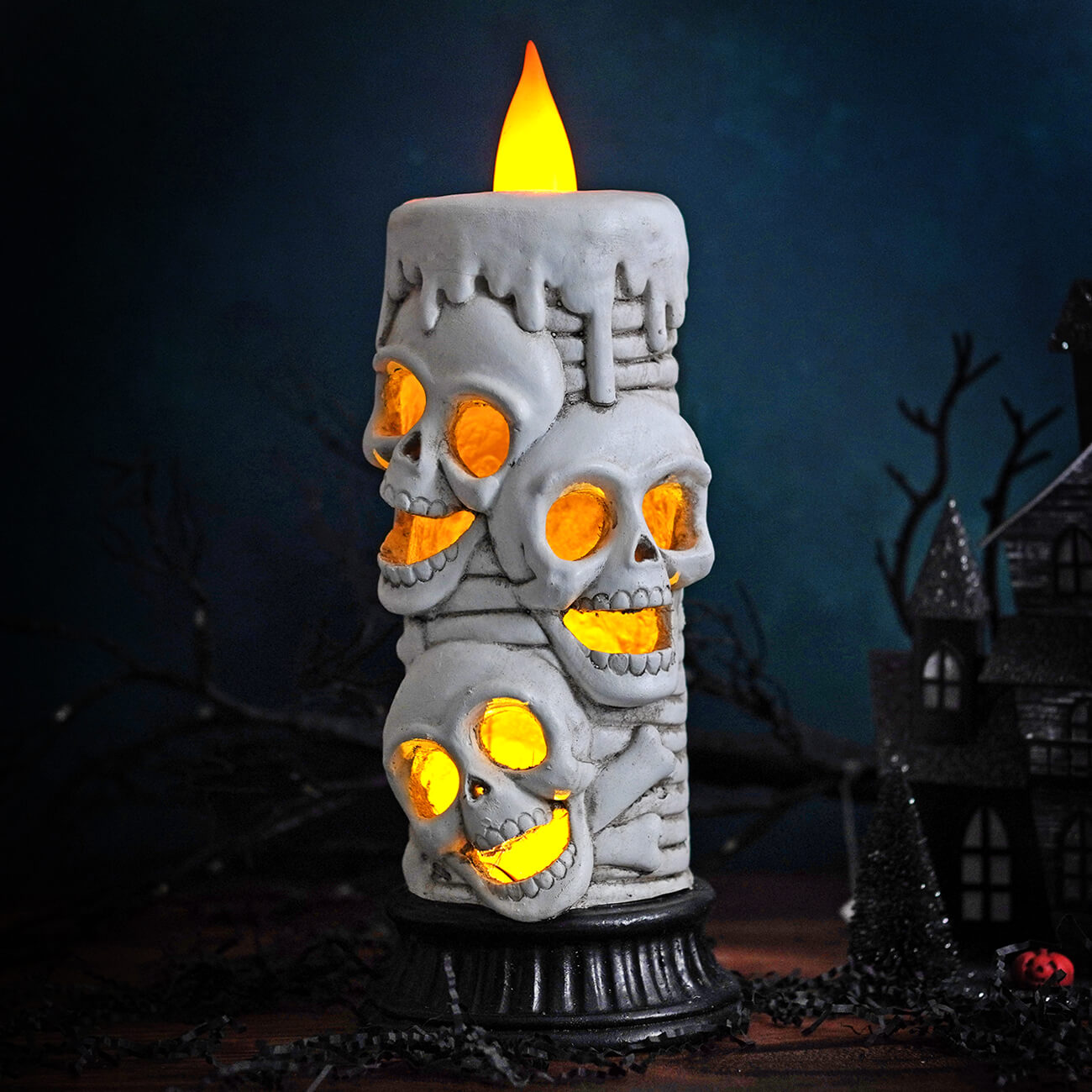 A white 16 inch large led skull candle with three stacked skulls glowing orange halloween lighted decor