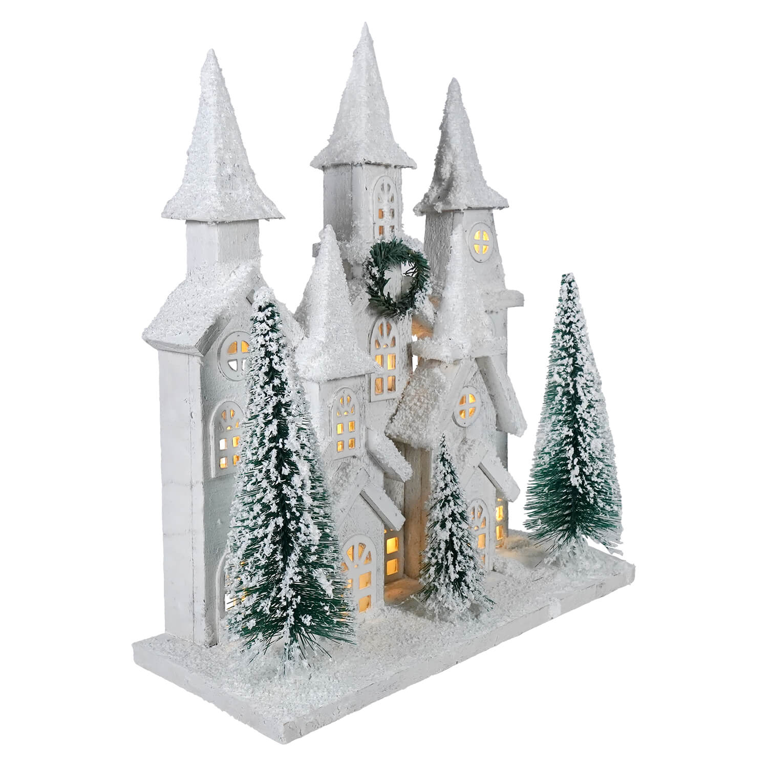 White snow-covered frosted wood house with glowing windows and bottle brush trees led lighted winter holiday decor
