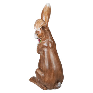 A detailed 16 inch serene brown bunny resin figurine clutching a spring floral bouquet with white tipped ears and paws