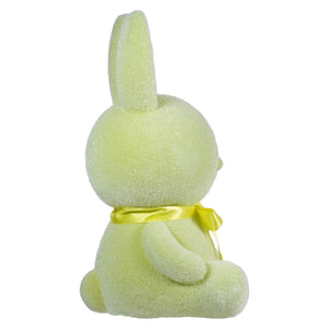 Yellow plush bunny with a bow tied around its neck, viewed from behind.