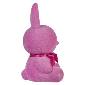 Pink plush bunny with a bow ribbon viewed from behind.
