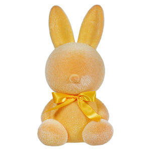 Yellow plush bunny with a gold satin bow around its neck.