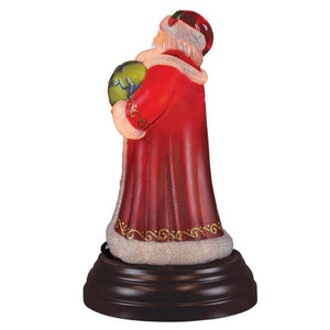 Red santa peace santa light with glittery white beard holding green globe on dark wooden base christmas lights decor
