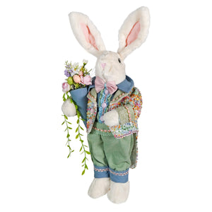 A 24 inch plush vintage easter bunny figural decor in a colorful jacket and green pants holding a pastel flower bouquet
