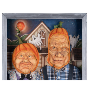 A framed Halloween art print featuring two scarecrows with pumpkin-shaped heads, standing in front of a haunted house and ghosts under a full moon.
