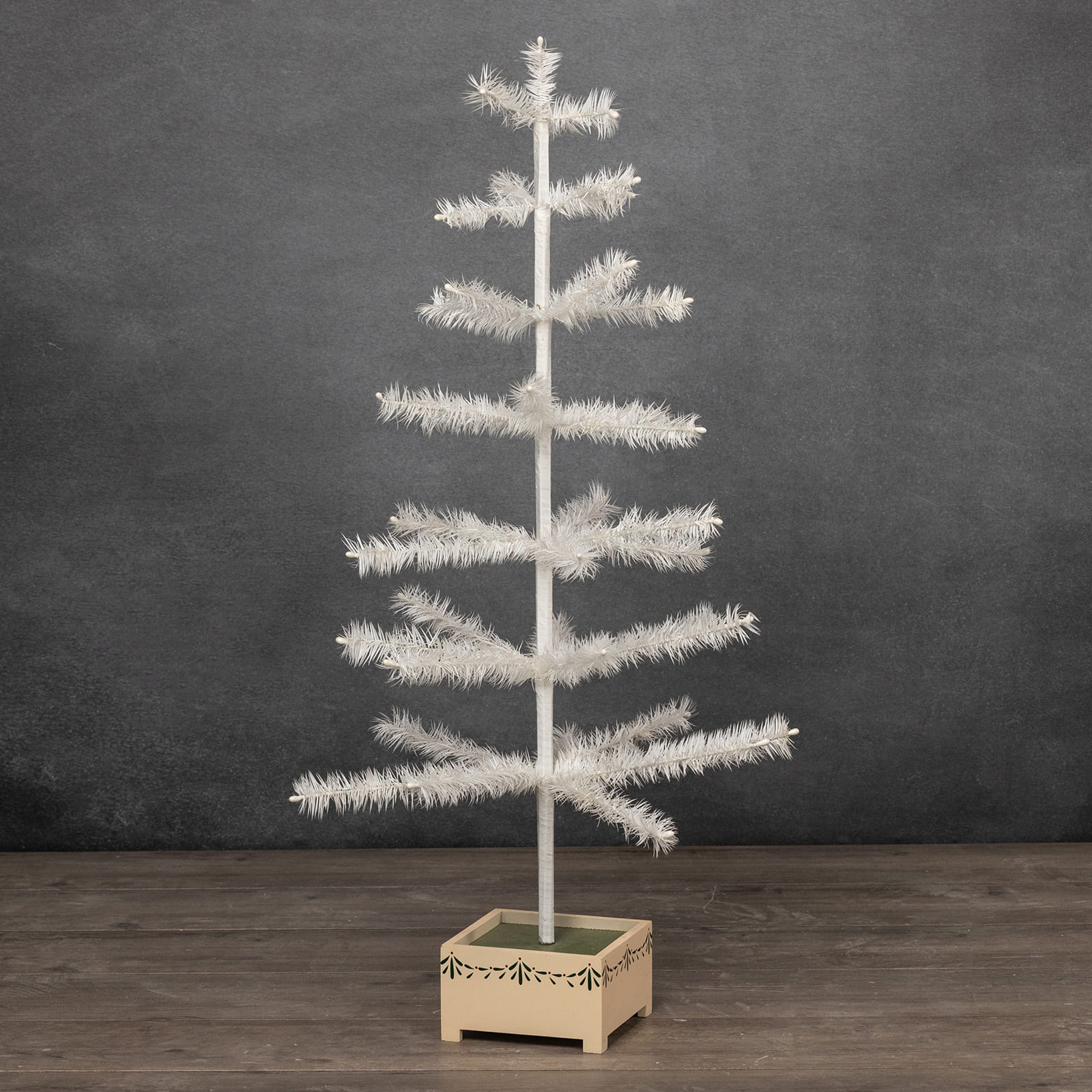 36 inch ivory feather tinsel tree with frosted branches in a wooden base featuring green leafy patterns