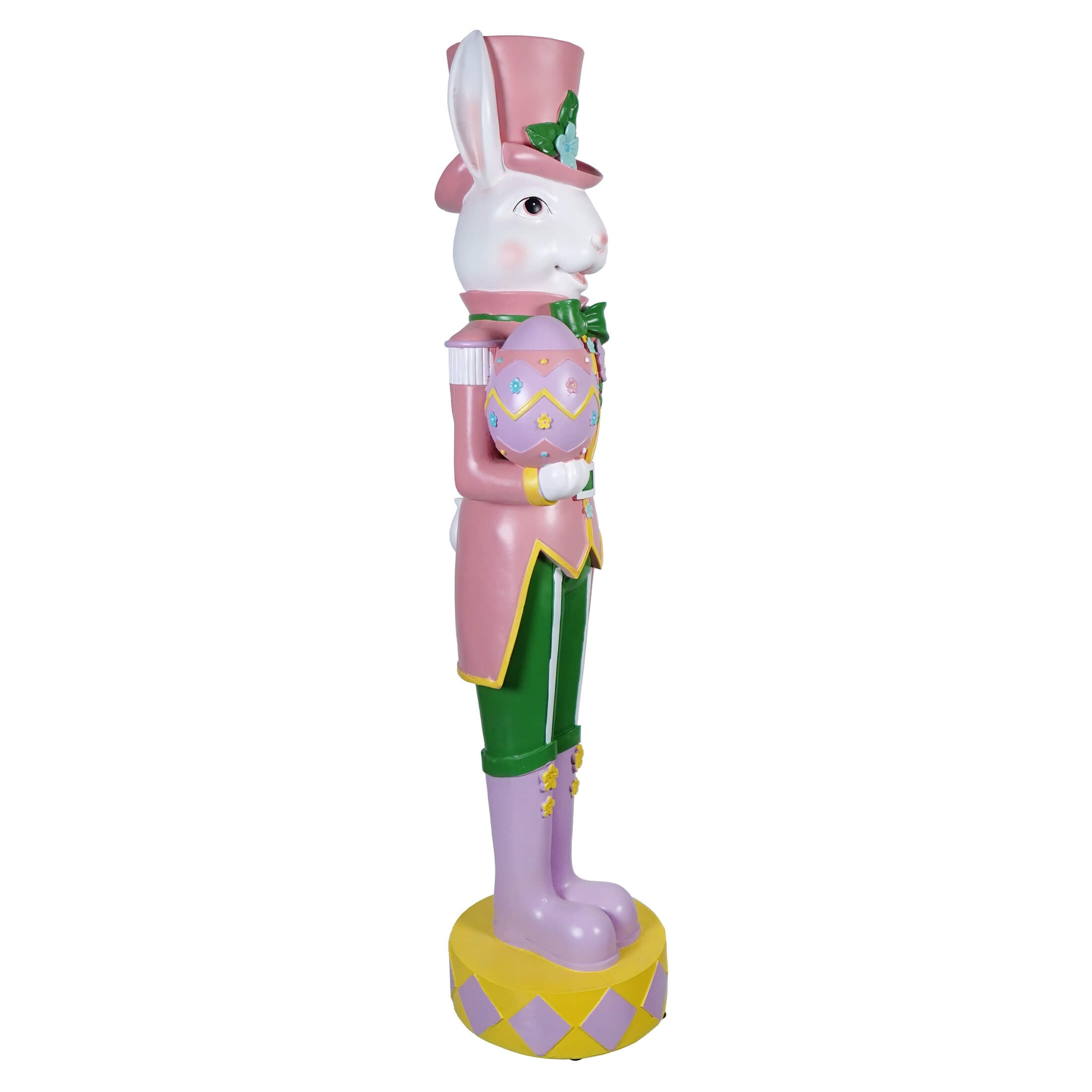 A decorative Easter bunny nutcracker wearing a pink coat, top hat, and purple boots.