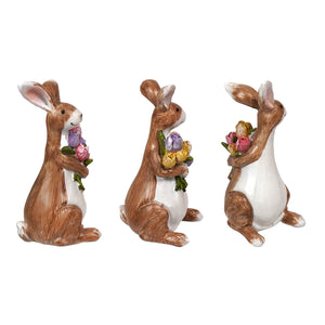 Three brown and white resin easter bunnies clutching colorful spring flower bouquets set of 3 figurines