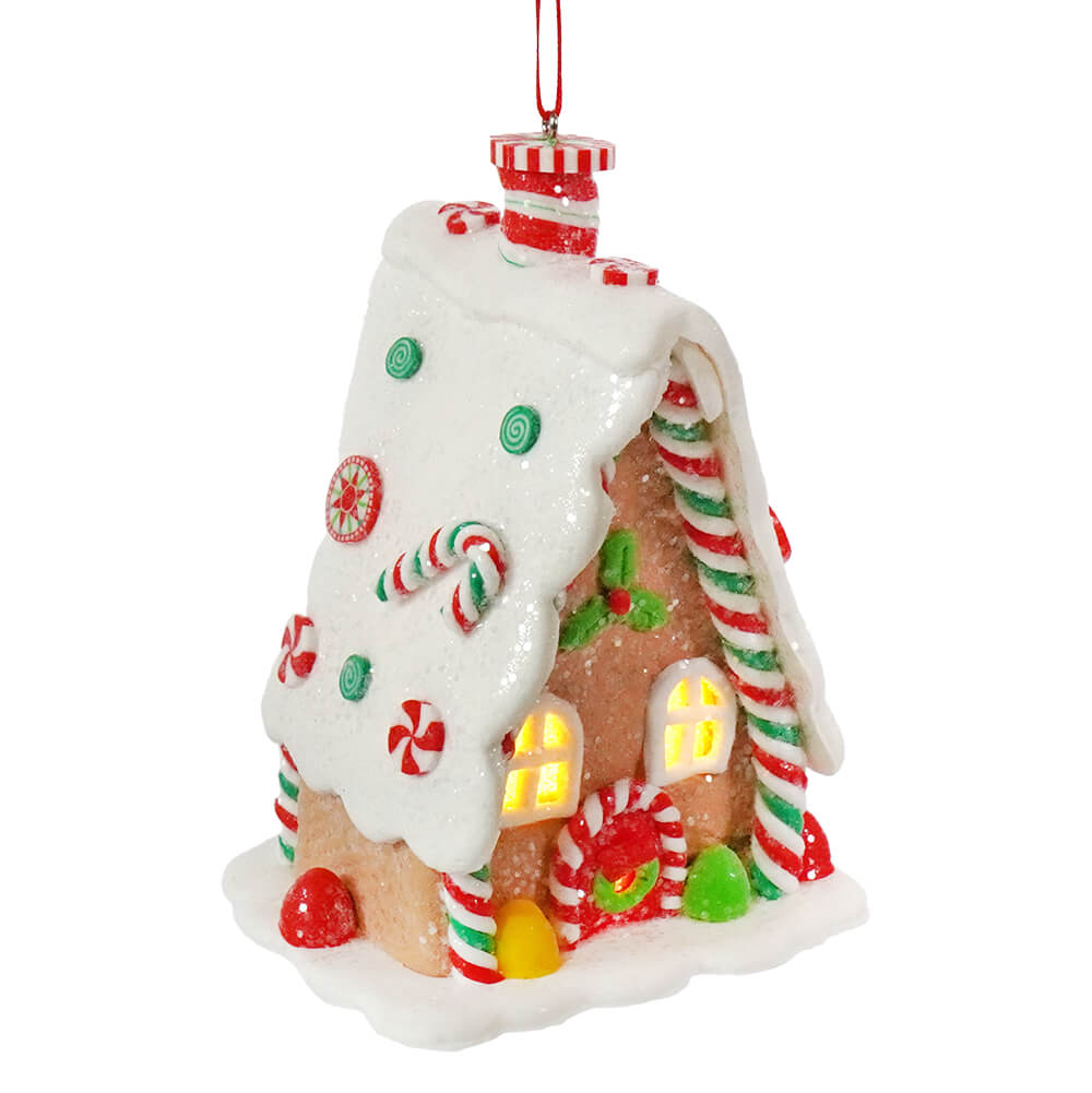 A 5 inch led lighted claydough gingerbread a frame house ornament with red candy canes green peppermint and glowing windows