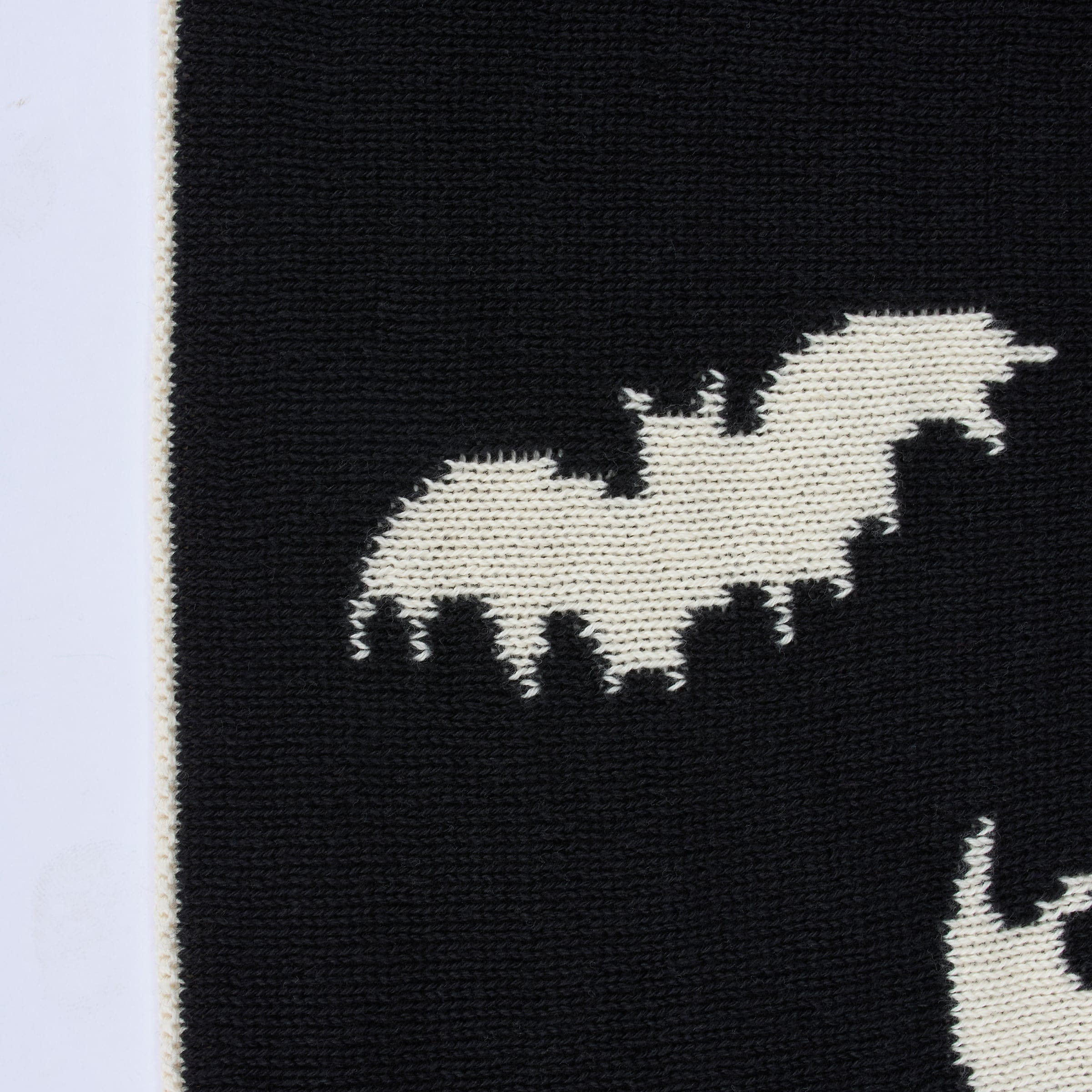 Black knitted throw blanket with a white bat design perfect for cozying up in spooky style