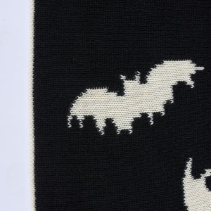 Black knitted throw blanket with a white bat design perfect for cozying up in spooky style