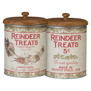 Two vintage-style metal reindeer treats canisters with wooden lids and festive red and green holiday designs on cream backgrounds