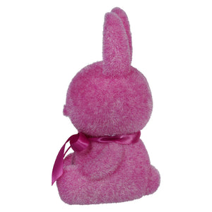 Pink plush bunny with a ribbon bow around its neck.