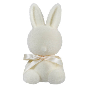 White plush bunny with a cream-colored ribbon bow around its neck.