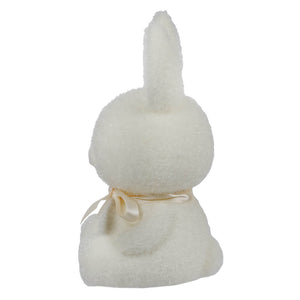 White plush bunny with a cream-colored ribbon around its neck.