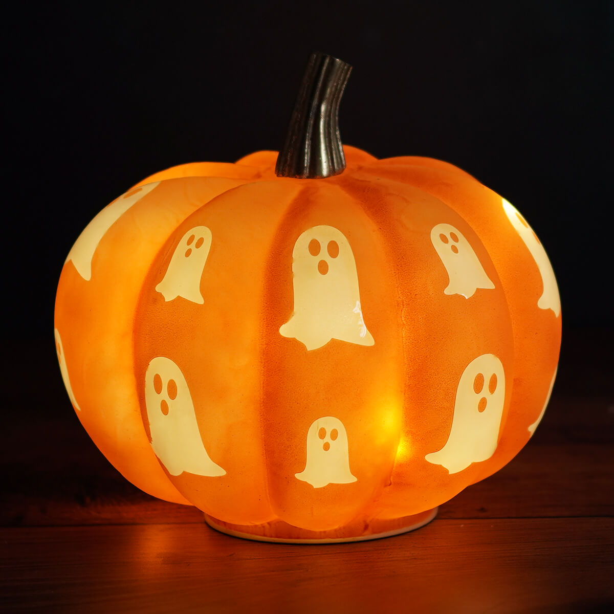 7 lighted glass orange pumpkin with spooky ghosts features a translucent orange lantern glowing from within
