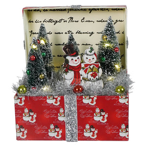 Red lighted vignette box christmas tabletop decor with silver ribbon snowmen and miniature trees winter scene