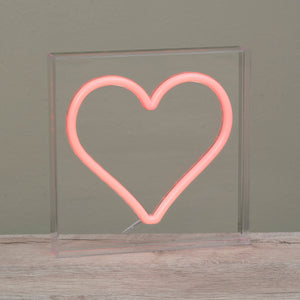 Pink neon heart light mounted on clear acrylic.