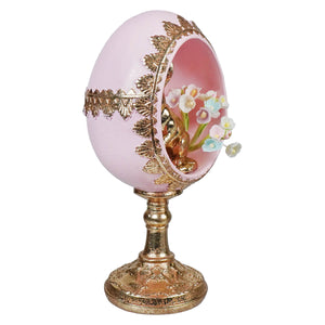 7 inch pink and gold bunny egg pedestal with delicate gold leaf and a miniature gold bunny among pastel flowers