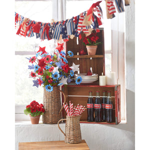 Patriotic red, white and blue star decorations arranged in a woven basket vase.
