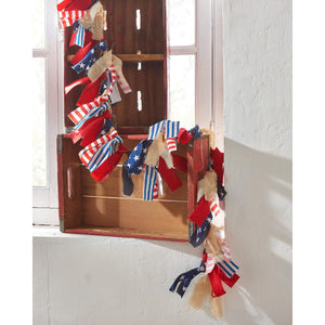 Patriotic red, white and blue fabric garland with tied ribbons and burlap accents.