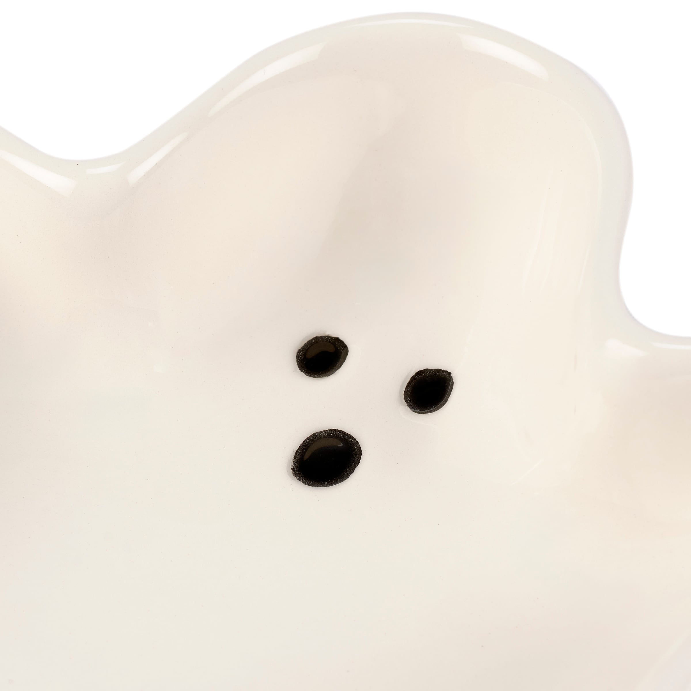 A white ceramic ghost tray in ghost shape with three black dot eyes perfect for halloween décor