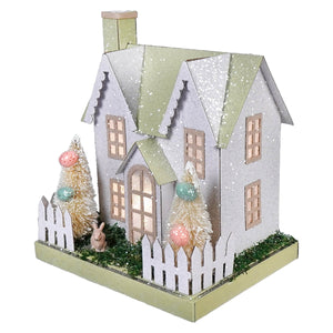 An 8 inch lighted led pastel green and pink bunny easter house with silver glitter, brown bunny decor, and illuminated windows