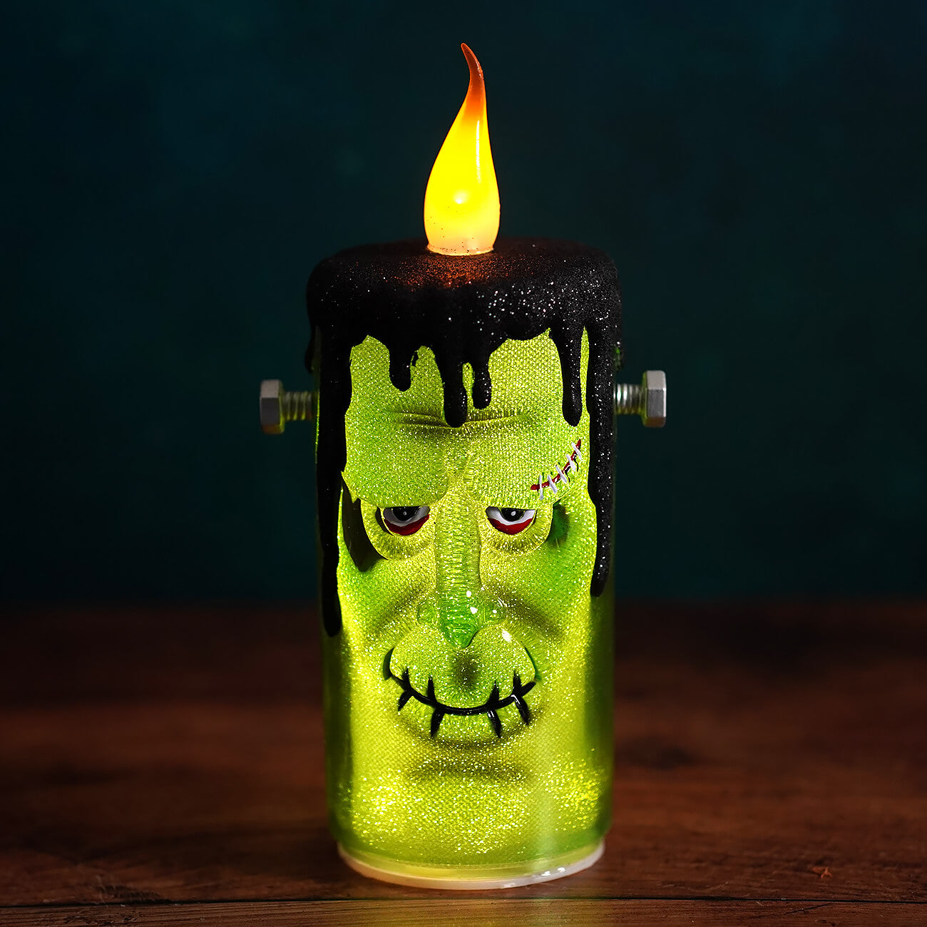 Green frankenstein flickering candle with black wax drips and metallic bolts perfect for halloween candles decor