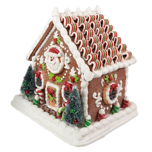 A 9.25 inch lighted gingerbread junction house with brown sugar exterior santa face and ribbon candy roof figural decor