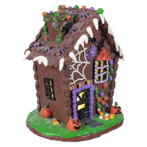 9.5 inch lighted halloween gingerbread house with brown glittery exterior, white icing, candy, spiderwebs, and pumpkins