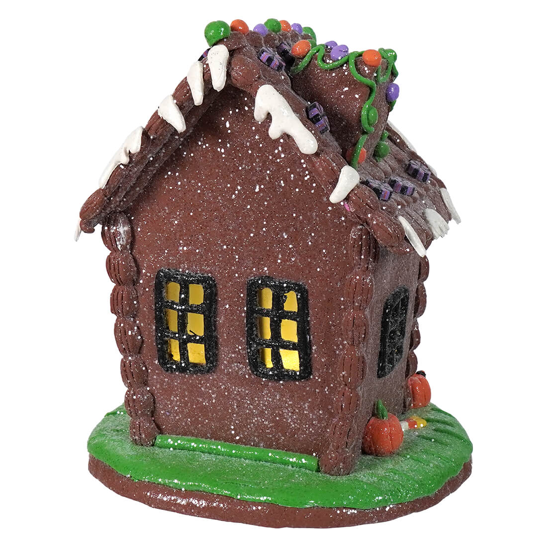 A glittery brown 9.5 inch lighted halloween gingerbread house with white icing drips and colorful candy roof decor