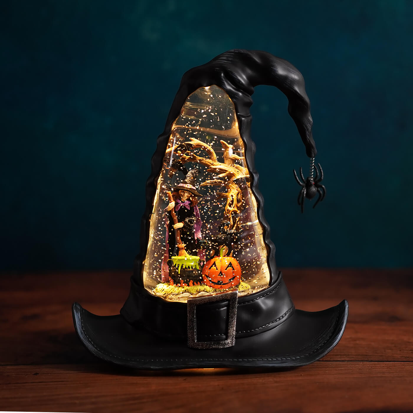 Black lighted swirling witch hat water globe with glowing snow-filled interior and miniature halloween figures inside