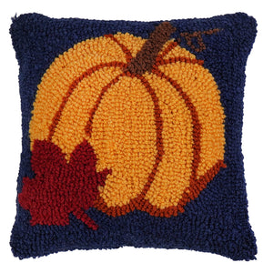 A 9 inch autumn pumpkin hooked pillow with a vibrant orange pumpkin and red leaf on a navy textured throw pillow