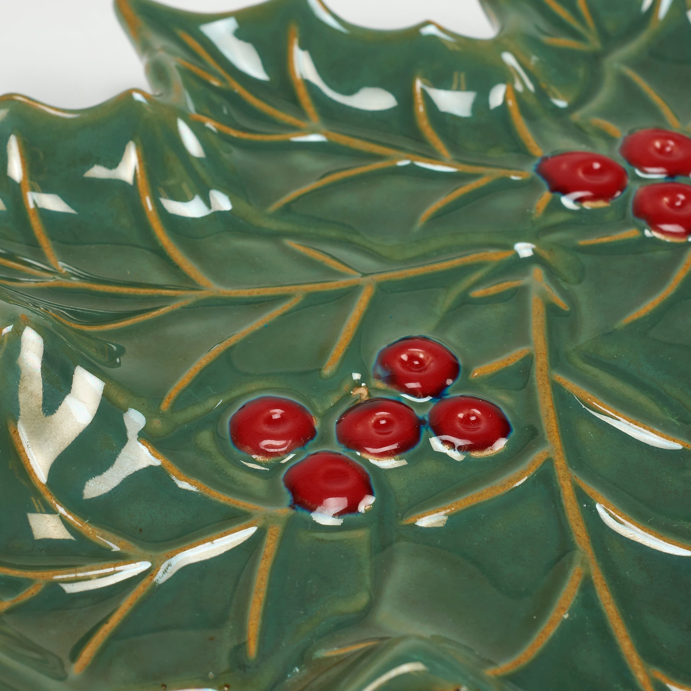 Green ceramic holly berry tree plate shaped like a holly leaf with glossy red berries and gold leaf veining