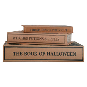 Three stacked faux book props with Halloween-themed titles: 'The Book of Halloween' on the bottom, 'Witches Potions & Spells' in the middle, and 'Creatures of the Night' on top, all in a tan faux-leather finish with black text and trim, shown on a white background.