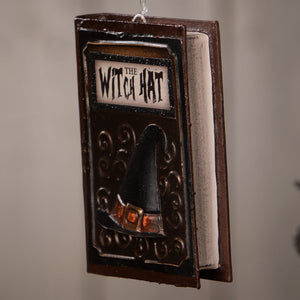 Dark brown bethany lowe witches & witch decor book ornament with black witch hat and orange buckle labeled the witch hat