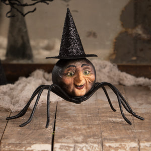 A whimsical black spider figurine with a painted human face and glittery witch hat perfect for halloween witches decor