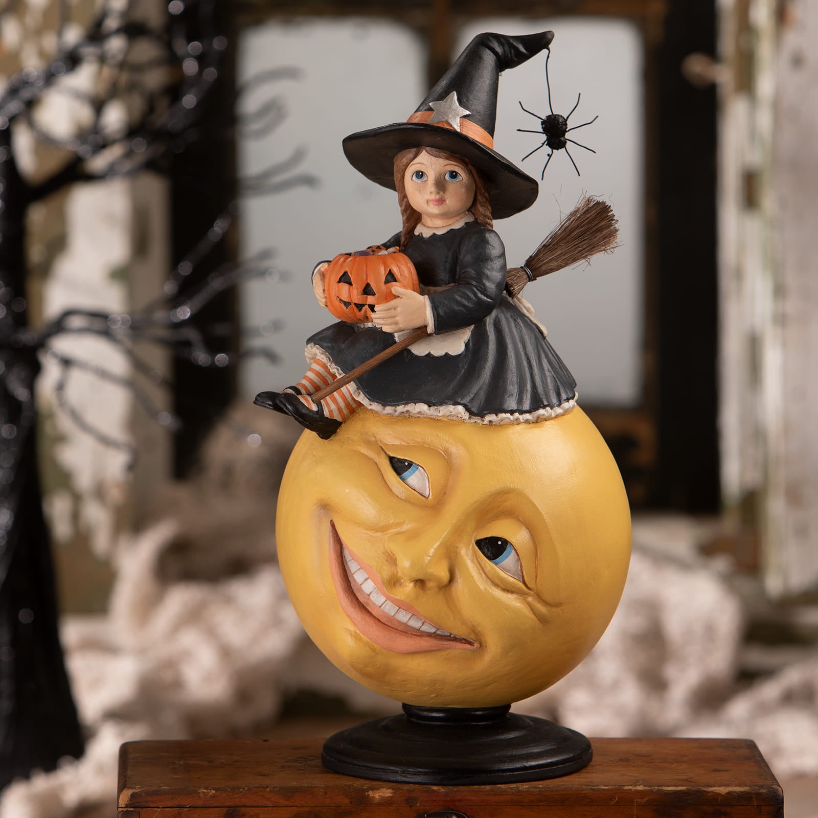 Hattie witch on moon figurine with a young witch in black dress riding a smiling yellow moon holding a pumpkin halloween witches decor