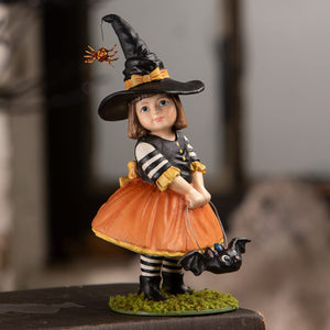Emery witch halloween witch decor figurine in black hat with orange spider wearing striped top and orange skirt on moss